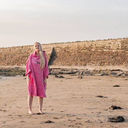 Person wearing the Dryrobe Organic Towelling Pink Robe facing front on the beach