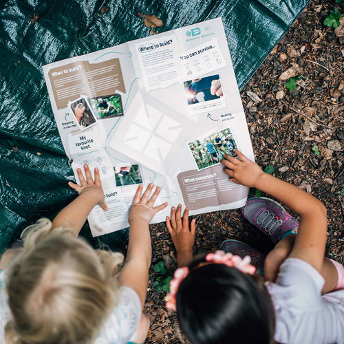 Child using the guide in the kit to build the shelter