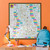 Framed ST&G's Great British Map of Wonders on an orange wall behind a child's desk