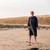 Person wearing the Dryrobe Organic Towelling Grey Robe facing front on a beach