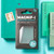 The MAGNiF-i Credit Card Magnifier in its retail packaging on a green book next to a used stamp to show its size