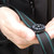 Person holding The Suunto Clipper L/B NH Compass clipped to some black and green webbing strap