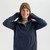 Person in blue top and facing front wearing an Ochre Heather Juneau Beanie Hat by Outdoor Research with a white background