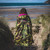 Person wearing the Dryrobe Advance Adults Camo Pink Long Sleeve Outdoor Robe walking on the beach away from the camera