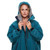 Close up of person wearing the Red Paddle Co Pro Change EVO Teal Long Sleeve Outdoor Robe unzipped facing forward with hood up