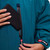 Close up of outer unzipped pocket Red Paddle Co Pro Change EVO Teal Long Sleeve Outdoor Robe with a phone being put in the pocket