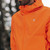 Person wearing Mac in a Sac Men's Venture Ultralite Neon Orange Running Jacket