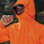Person wearing Mac in a Sac Men's Venture Ultralite Neon Orange Running Jacket with hood up and toggle pulled