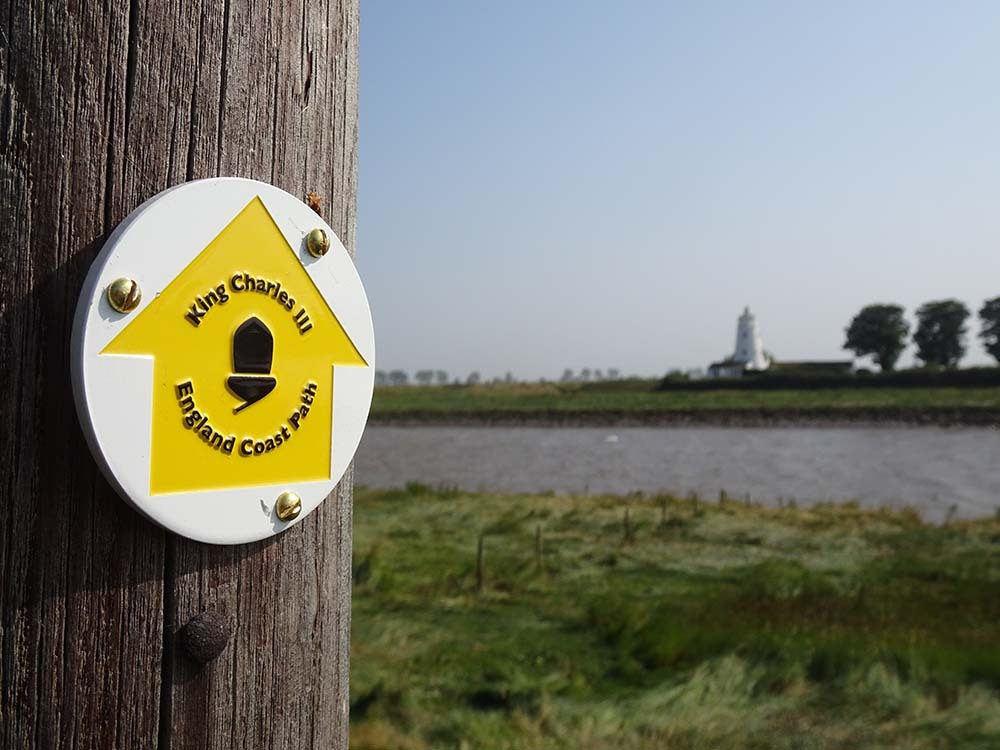 Post with a route arrow: King Charles III Coastal Path