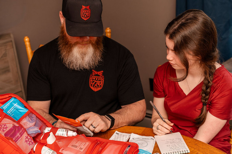 Instructor providing 1-on-1 briefing on trauma kit components and first aid supply management from MyMedic with 1791 TAT.