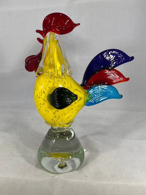 Side view of the vintage MCM Murano glass rooster, highlighting the yellow pattern in the rooster's body and the detail of his blue and red tail feathers, and green wing.