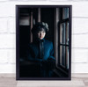 Asian woman in blue by window staring Wall Art Print