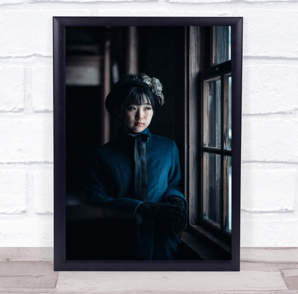 Asian woman in blue by window staring Wall Art Print