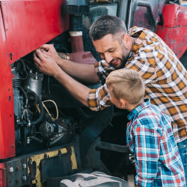 Father and son fixing tractor