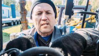 Man inspecting tractor engine
