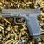 Ruger RXM 9mm optics ready pistol with Magpul gray frame, tritium front sight, and 15-round magazine, in store image on top of ammo casings