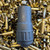 Stealth Additive Works TISHA 9mm suppressor with titanium construction and low back pressure design laying down on empty ammo casings, in store image
