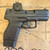 Heckler and Koch VP9CC 9mm micro-compact pistol with Vortex Defender CCW red dot optic and tritium front sight, in store image pointing to the right