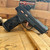 Sig Sauer P322 ROSE .22 LR pistol with factory-installed ROMEO-RS optic, threaded barrel, fiber optic sights, rose gold accents, and black polymer frame, in store image angled downward