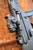 HK SP5 9mm short-barreled rifle with fixed stock, HUXWRX FLOW 9K Ti suppressor, Aimpoint Micro T-2 optic and SureFire Scout Light, outside top of optic view