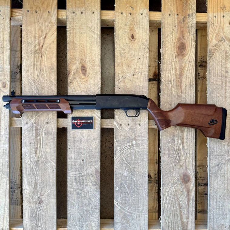 Mossberg 590S Shockwave 12 gauge pump action firearm featuring WOOX Gladiatore American walnut grip and M-LOK forend upgrade, matte blue finish, 14.375-inch barrel, and compact defensive configuration, in store image