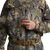 A full-body studio image of the Sitka Delta VentLite Zip GTX Wader is shown from the front, featuring the specific GORE OPTIFADE Timber camouflage pattern. The image highlights the full-length, waterproof YKK AquaSeal front zipper that runs down the center of the chest and torso. The upper wader is made of breathable, durable GORE-TEX Pro fabric with reinforced Cordura panels on the knees and shins. The integrated VentLite boots, insulated with PrimaLoft Gold and featuring a rugged Vibram Megagrip outsole, are visible at the bottom. The wader includes high handwarmer pockets, adjustable suspenders, and a wading belt. The SITKA logo is clearly visible on the chest. The background is a clean, neutral white.