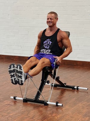 Man Doing legs exercise with intense resistance band holding intense resistance bands handle grips on intense band adjustable exercise bench