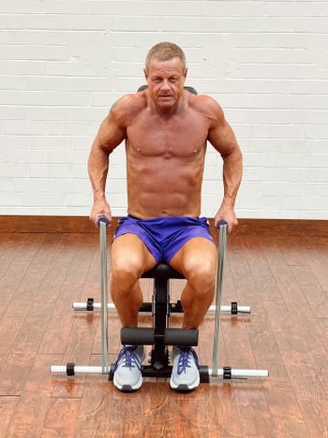 Man Doing shoulders exercise with intense resistance band holding intense resistance bands handle grips on intense band adjustable exercise bench