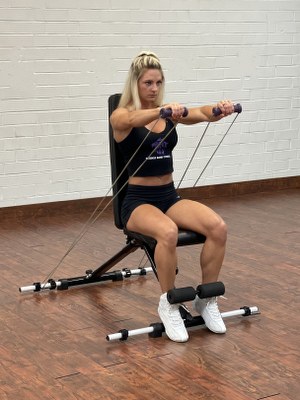 woman doing arms exercise with intense resistance band holding intense resistance bands handle grips on intense band adjustable exercise bench