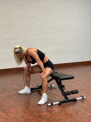 woman doing arms exercise with intense resistance band holding intense resistance bands handle grips on intense band adjustable exercise bench