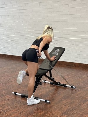 woman doing Wings exercise with intense resistance band holding intense resistance bands handle grips on intense band adjustable exercise bench