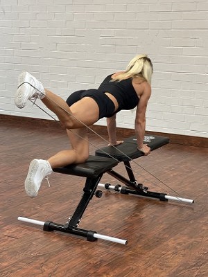woman doing leg exercise with intense resistance band on intense band adjustable exercise bench