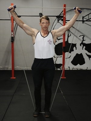 Man Stretching intense resistance bands holding intense resistance bands handle grips  in gym 