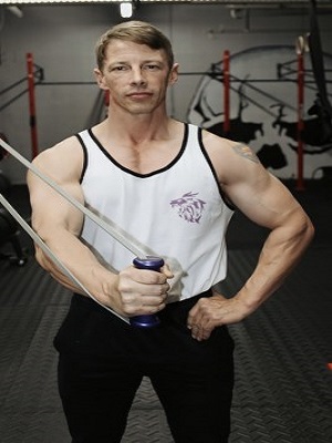 Man Stretching intense resistance bands holding intense resistance bands handle grips  in gym  by standing
