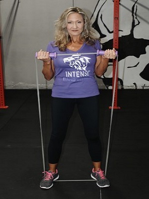 women stretching intense resistance bands holding intense resistance bands handle grips in hands 
