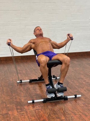 Man Doing chest exercise with intense resistance band holding intense resistance bands grips on adjustable exercise bench 