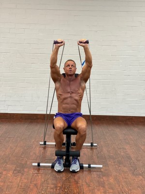 Man Doing shoulders exercise with intense resistance band holding intense resistance bands handle grips on adjustable exercise bench