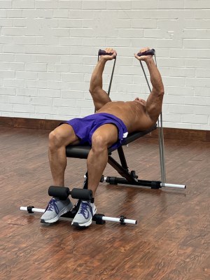 Man Doing shoulders exercise with intense resistance band holding intense resistance bands handle grips on adjustable exercise bench