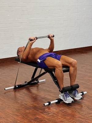 Man Doing chest exercise with intense resistance band holding intense resistance bands handle grips on adjustable exercise bench