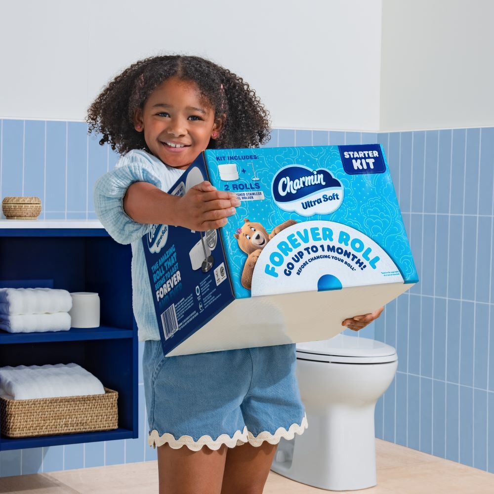 little girl holding a box of Charmin Forever Roll
