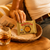Tortuga Golden Original Snack Rum Cake displayed on a woven tray with glass of rum.