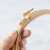 Close-up of DMC wooden triangle embroidery hoop with smooth finish and clasp.