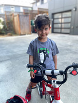 Child outdoors wearing a Heather Grey Seattle soccer orca shirt