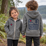 Two children showing the front chest mark and large Pacific Northwest back print on grey zip hoodies