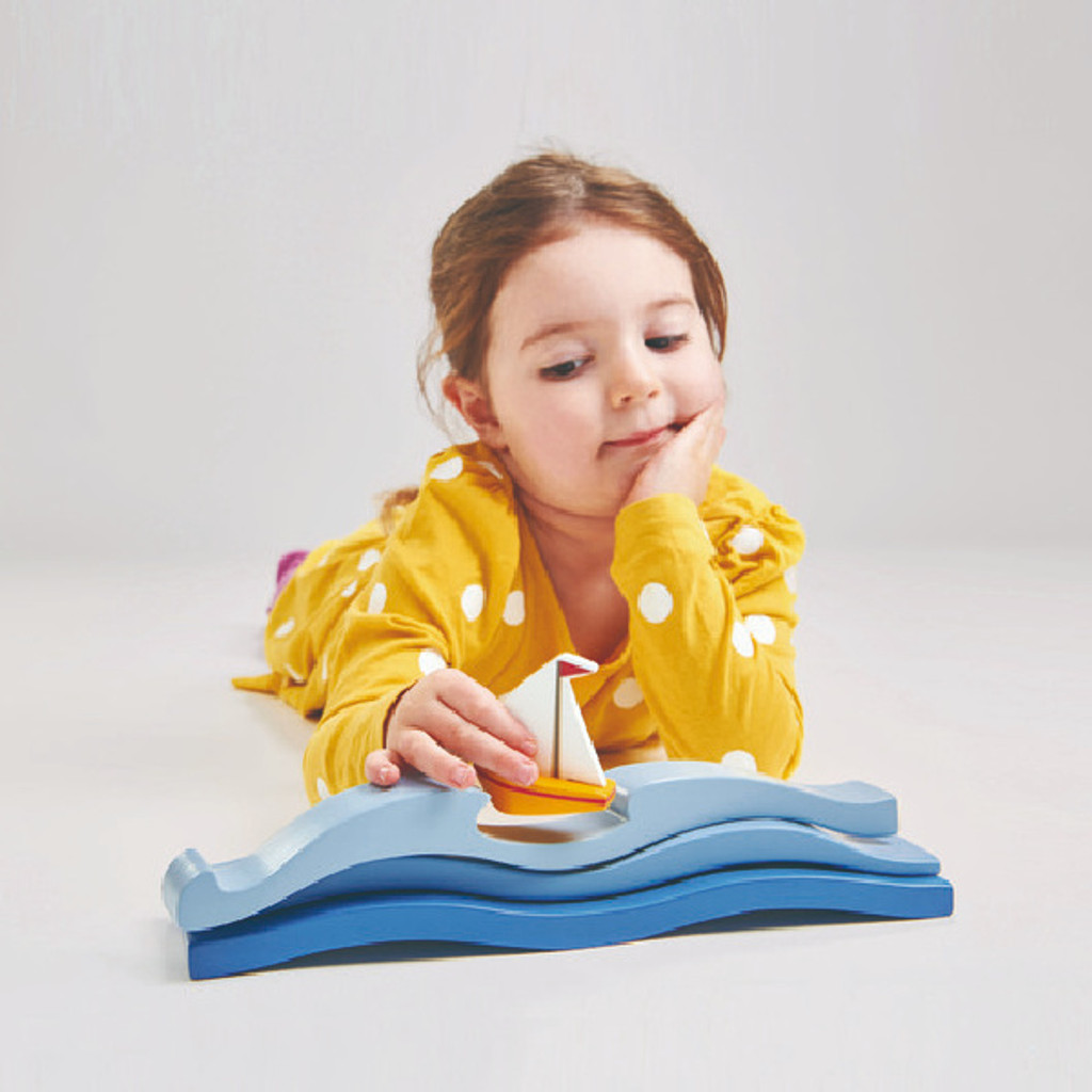 Girl playing with Tender Leaf Toys Blue Water with sailboat