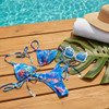Triangle bikini set with spaghetti straps, golden details and scrunchie back in vibrant coral and shells pattern. 