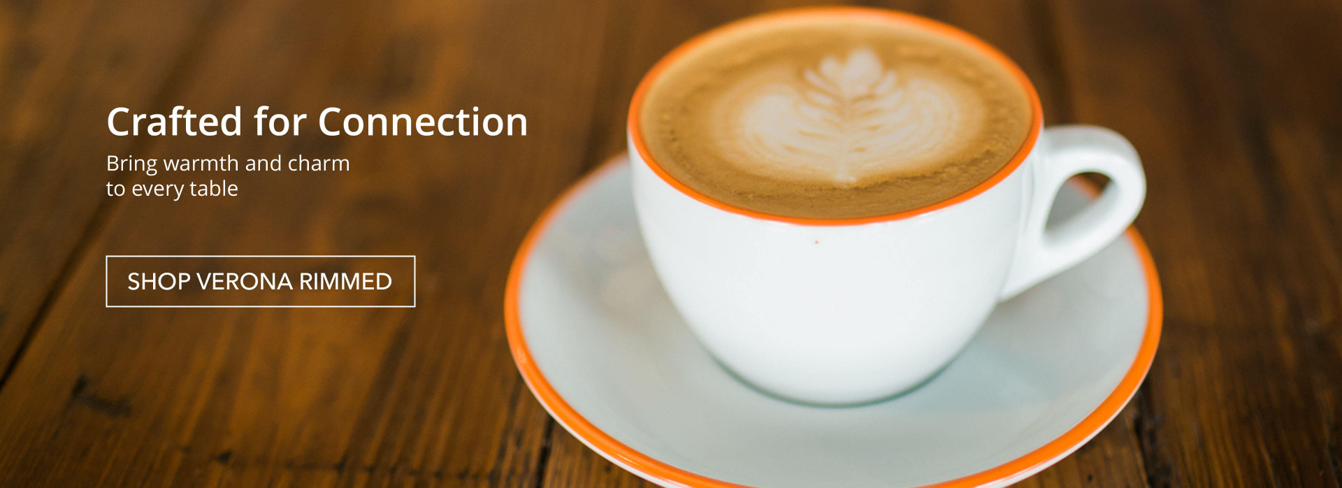 Ancap rimmed cappuccino cup on wooden table.