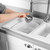 Washing up brush with white bristles and pink handle, shown on white background