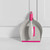 Pink dustpan and brush set stored in a white cupboard with cleaning supplies.