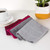 Set of three microfibre cleaning cloths in grey, red, and burgundy on white background